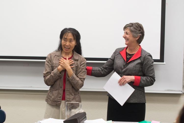Provost Maria Pallavicini informing Professor Xiaojing Zhou that she had won the 2015 Distinguished Faculty Award.